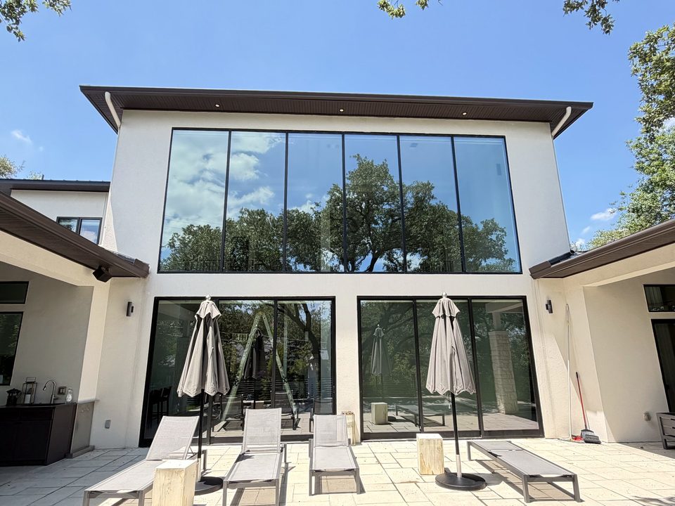 Two-story stucco home with a wall of floor-to-ceiling windows and patio doors, a Casa Care residential window cleaning job