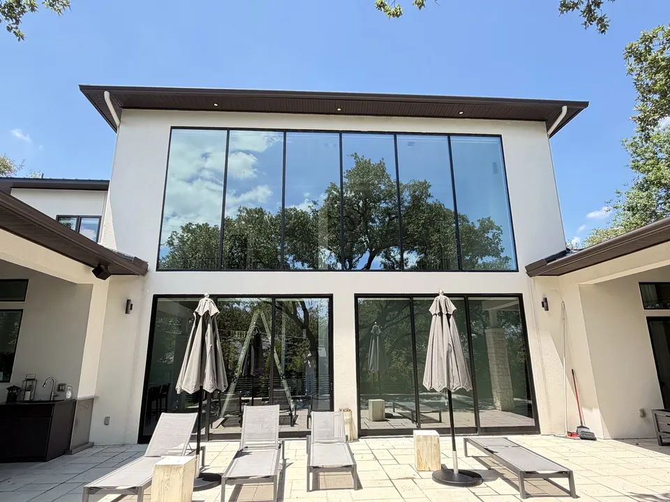 Two-story stucco home with a wall of floor-to-ceiling windows and patio doors, a Casa Care residential window cleaning job