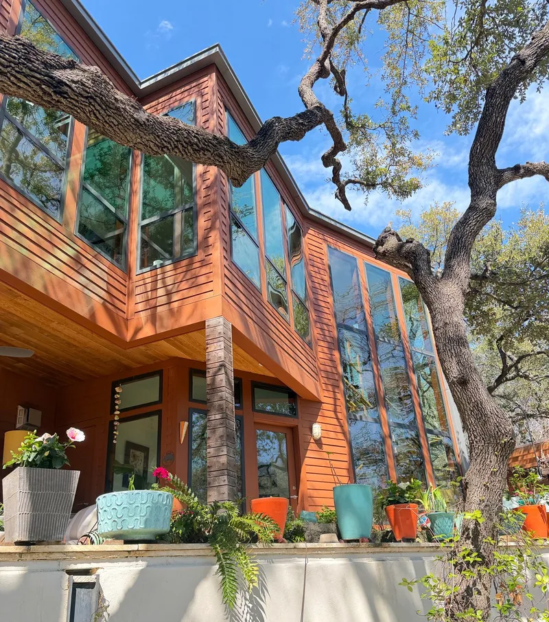 Tall windows on a cedar-and-stucco home under live oaks, a Casa Care window cleaning job