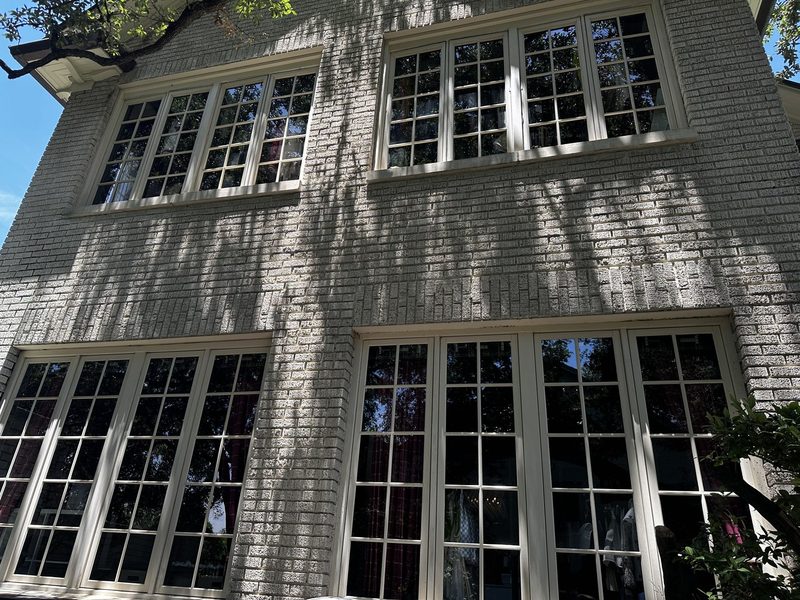 Divided-light French casement windows on a painted brick home, a Casa Care window cleaning job