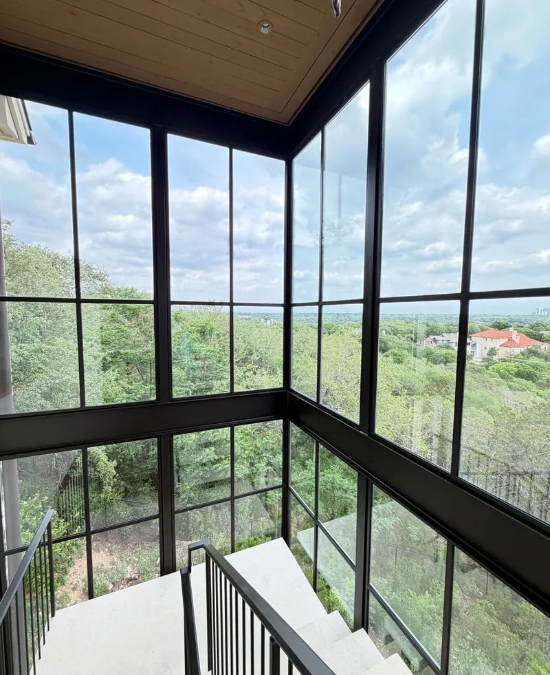 Floor-to-ceiling glass stairwell windows overlooking trees, cleaned by Casa Care